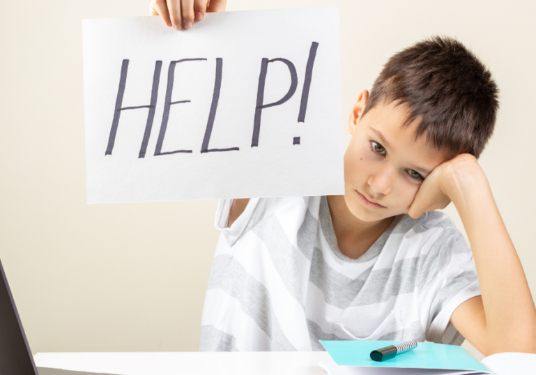 Boy seeking help while learning on a computer. An Education Specialist with The Burdekin Association could help him.